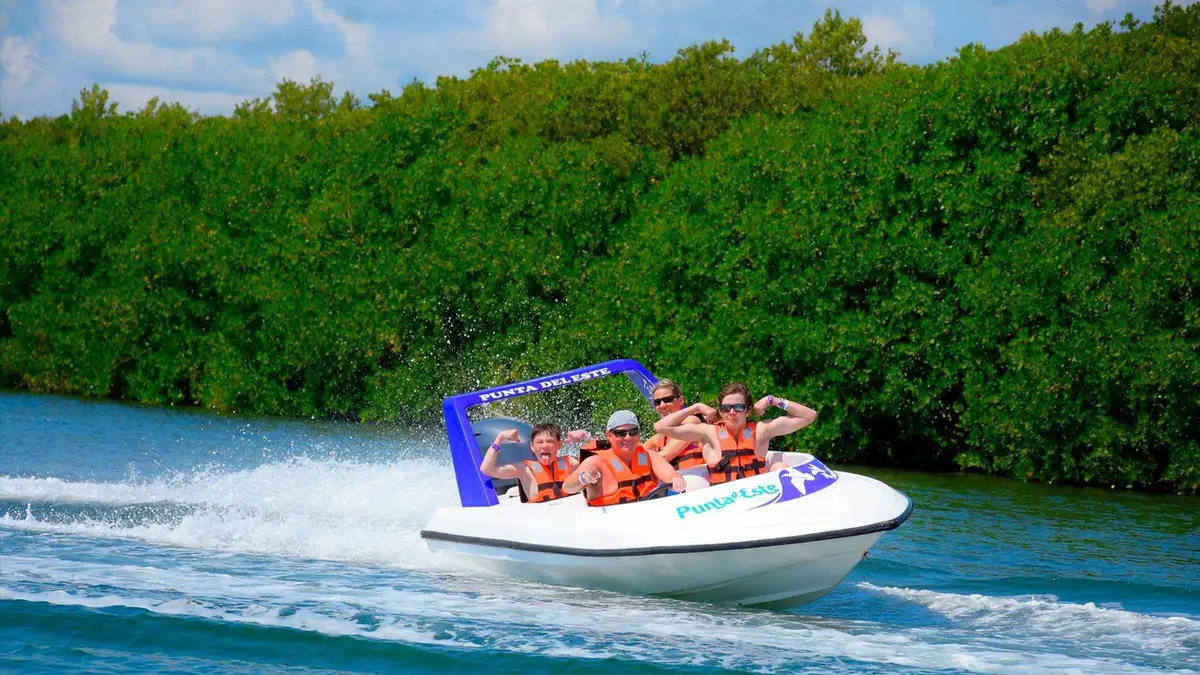 Two travellers driving a speedboat through the Nichupte lagoon mangroves on the Cancun jungle tour speedboat and snorkeling adventure, Mexico
