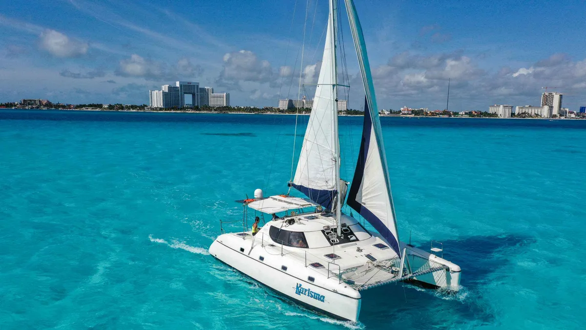 Private catamaran under sail off Isla Mujeres with snorkel gear rigged on the half day private catamaran tour from Cancun, Mexico